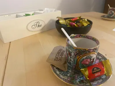 a cup of coffee on a plate with a spoon in it at Villetta Garbata in Rome