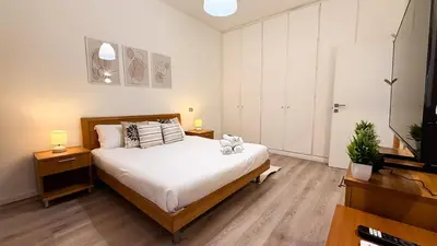 a bedroom with a bed and two lamps and a television at Elegant Stay a Stone's Throw from Libya Metro in Rome
