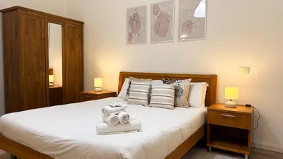 a bedroom with a large white bed with two lamps at Elegant Stay a Stone's Throw from Libya Metro in Rome