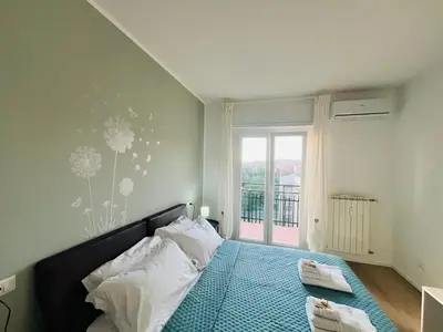 a bedroom with a bed with a blue bedspread and a window at Sunny Stay with a Roman Soul in Rome