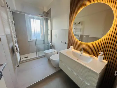 a bathroom with a sink and a toilet and a mirror at Sunny Stay with a Roman Soul in Rome