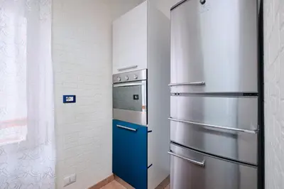 a kitchen with a refrigerator and a stove at Metro A 10 minutes - Free Wi-Fi & Netflix in Rome