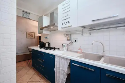 a kitchen with blue cabinets and a sink at Metro A 10 minutes - Free Wi-Fi & Netflix in Rome