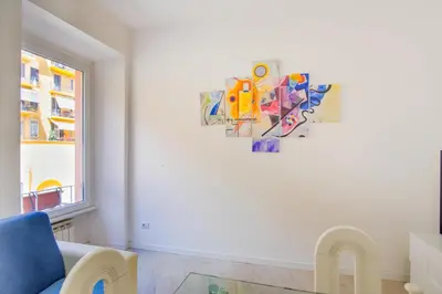 a living room with a blue couch and a painting on the wall at Elegantis Doris Suite Apartment - One Minute Walk to Vatican Museums in Rome
