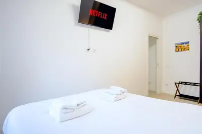 a room with a bed with a tv on the wall at Elegantis Doris Suite Apartment - One Minute Walk to Vatican Museums in Rome