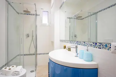 a bathroom with a sink and a glass shower at Elegantis Doris Suite Apartment - One Minute Walk to Vatican Museums in Rome