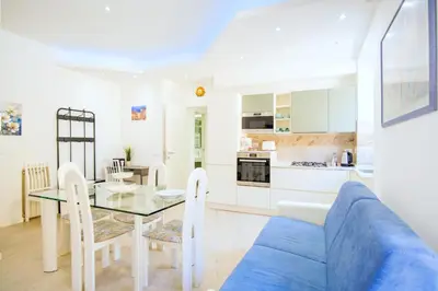 a kitchen and living room with a blue couch and a table at Elegantis Doris Suite Apartment - One Minute Walk to Vatican Museums in Rome
