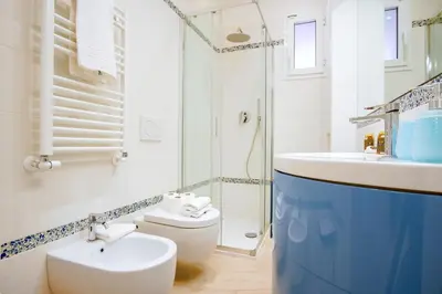 a white bathroom with a sink and a toilet at Elegantis Doris Suite Apartment - One Minute Walk to Vatican Museums in Rome