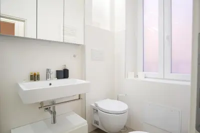 a white bathroom with a sink and a toilet at Elegantis Trastevere Modern Apartment - Comfort in Rome Most Charming District in Rome