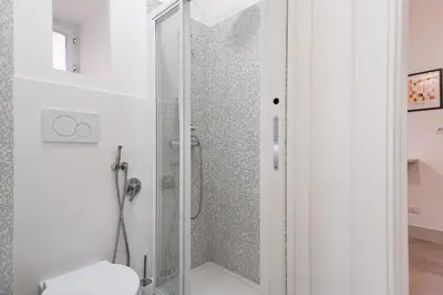 a shower with a glass door in a bathroom at Elegantis Trastevere Modern Apartment - Comfort in Rome Most Charming District in Rome