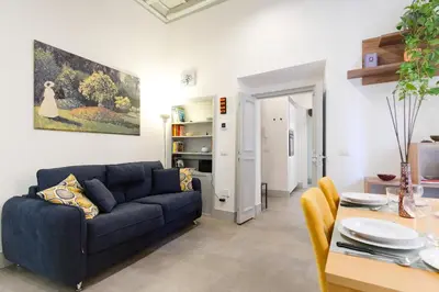 a living room with a blue couch and a table at Elegantis Trastevere Modern Apartment - Comfort in Rome Most Charming District in Rome