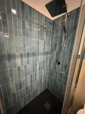 a bathroom with a shower with blue tiles at Elephant Parliament Apt in Rome