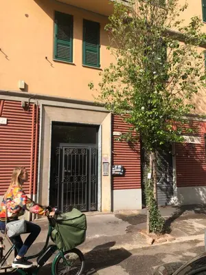 a woman riding a bike in front of a building at Testaccio Room in Rome in Rome