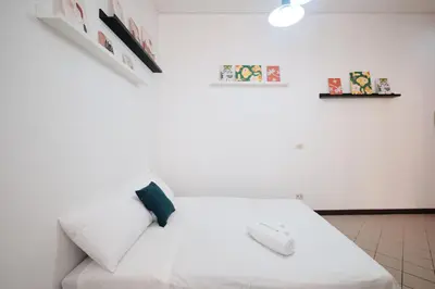 a bedroom with a white bed with a computer mouse on it at Tuscolana Station - 10 minutes from Metro A in Rome