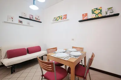 a dining room with a table and chairs and a couch at Tuscolana Station - 10 minutes from Metro A in Rome