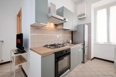 a kitchen with a stove and a refrigerator at Tuscolana Station - 10 minutes from Metro A in Rome