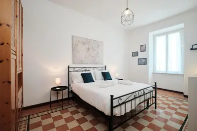a bedroom with a large white bed with blue pillows at Tuscolana Station - 10 minutes from Metro A in Rome