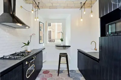 a kitchen with black cabinets and a sink and a stove at YCH-Laterano Charme in Rome