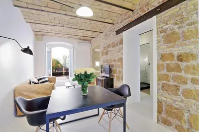 a living room with a table and chairs and a brick wall at YCH-Laterano Charme in Rome