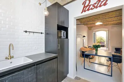 a kitchen with a sink and a table at YCH-Laterano Charme in Rome