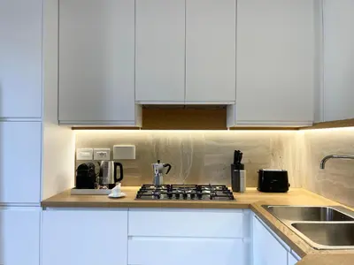a kitchen with white cabinets and a stove top oven at Terme di Tito Colosseum in Rome