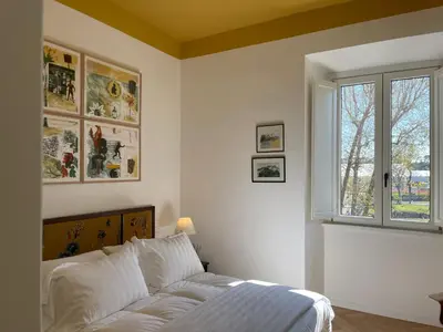 a white bedroom with a bed and a window at Terme di Tito Colosseum in Rome