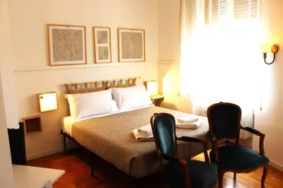 a bedroom with a bed with two chairs and a window at Vatican Home - San Pietro - Near to Metro A in Rome