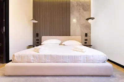 a bedroom with a bed with white sheets and pillows at Minerva Boutique Suites in Rome