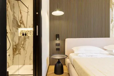 a bedroom with a bed and a glass shower at Minerva Boutique Suites in Rome