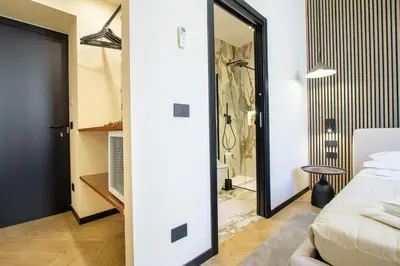 a bedroom with a bed and a glass door to a bathroom at Minerva Boutique Suites in Rome