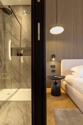 a bedroom with a shower and a bed and a table at Minerva Boutique Suites in Rome