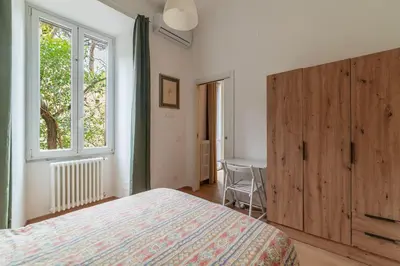 a bedroom with a bed and a window and a table at GuestHost - Roma Termini Lovely Flat in Rome