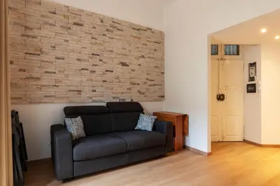 a living room with a couch and a brick wall at GuestHost - Roma Termini Lovely Flat in Rome