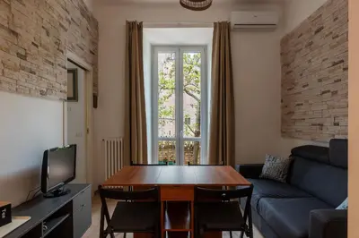 a living room with a table and a couch at GuestHost - Roma Termini Lovely Flat in Rome