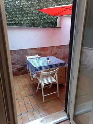 a table and chairs on a patio with an umbrella at My Cocoon in Rome