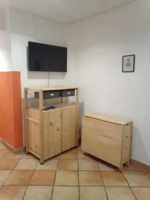 a room with a flat screen tv and a wooden cabinet at My Cocoon in Rome