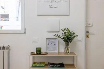 a vase of flowers on a table next to a door at NOSTROMONDO-Elegant Suite with patio in Monti Parioli in Rome