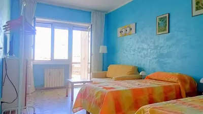 a blue bedroom with two beds and a window at A casa di Ugo - Colors and space at Pigneto, Rome in Rome