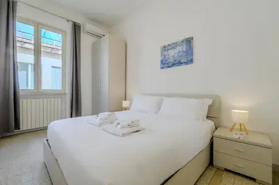 a bedroom with a large white bed and a window at Operetta View Apartment in Rome