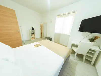 a white room with a bed and a desk and a television at La Stella di Roma al Vaticano in Rome