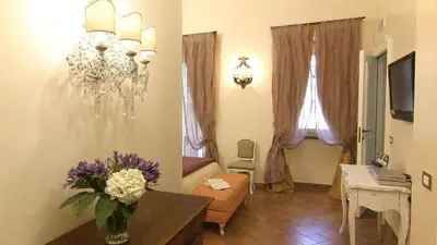 a living room with a vase of flowers on a table at Respighi Apartments - Rome City Center in Rome