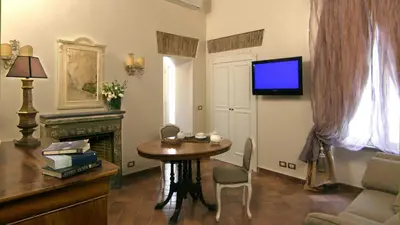 a living room with a table and a tv on the wall at Respighi Apartments - Rome City Center in Rome