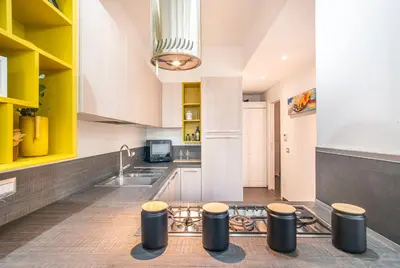 a kitchen with yellow and white cabinets and a sink at Battistini Pretty Apartment in Rome
