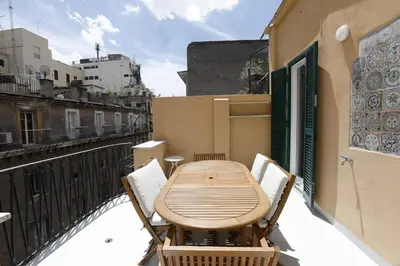 a wooden table and chairs on a balcony at Colosseum Panoramic Terrace in Rome