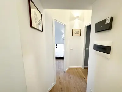 a hallway with white walls and a door with a mirror at Urban Loft 55 in Rome