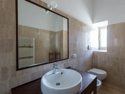 a bathroom with a sink and a toilet and a mirror at Vittorio Panoramic Apartment in Rome