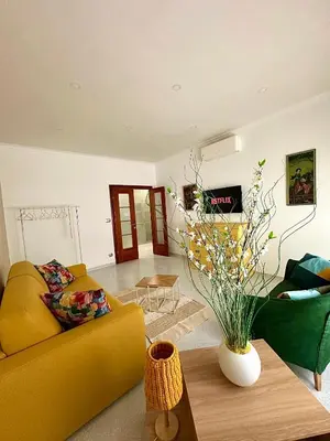a living room with a yellow couch and a table at Residenza Tulipano in Rome