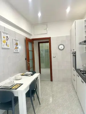 a white kitchen with a white table and chairs at Residenza Tulipano in Rome