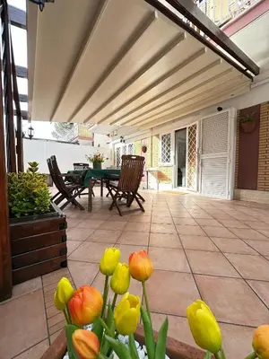 a patio with a table and chairs and yellow flowers at Residenza Tulipano in Rome
