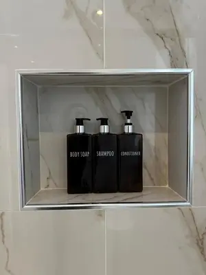 two black bottles sitting on a shelf in a bathroom at Vatican deluxe apartment - Casa Cesarina in Rome
